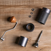 Dark grey hand grinder with wood handle. Hand grinders that are best for grinding filter and espresso beans. Shown, is a hand grinder taken apart.